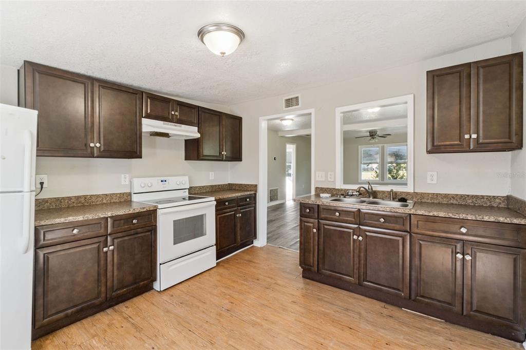 40542 West 3rd Avenue Umatilla, FL 32784 - Photo 5 of 13 a kitchen with stainless steel appliances granite countertop a stove top oven sink and cabinets