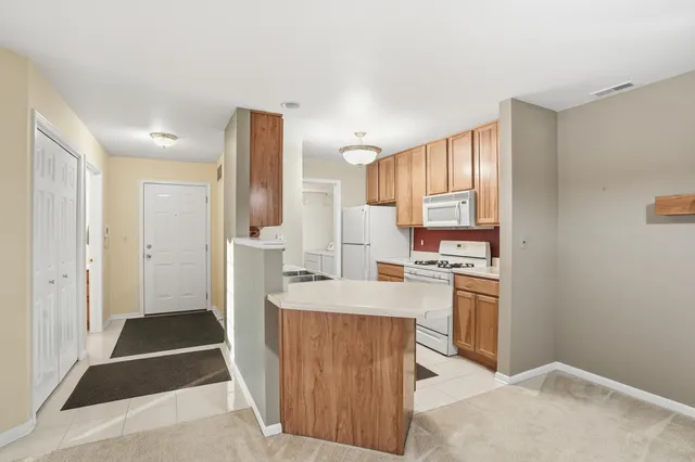 a kitchen with stainless steel appliances kitchen island granite countertop a refrigerator stove top oven and sink