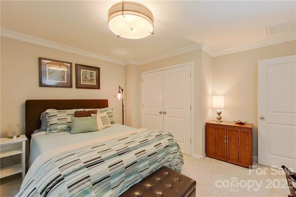 511 Upper Stone Circle Charlotte, NC 28211 - Photo 17 of 32 a bedroom with a bed and a chandelier