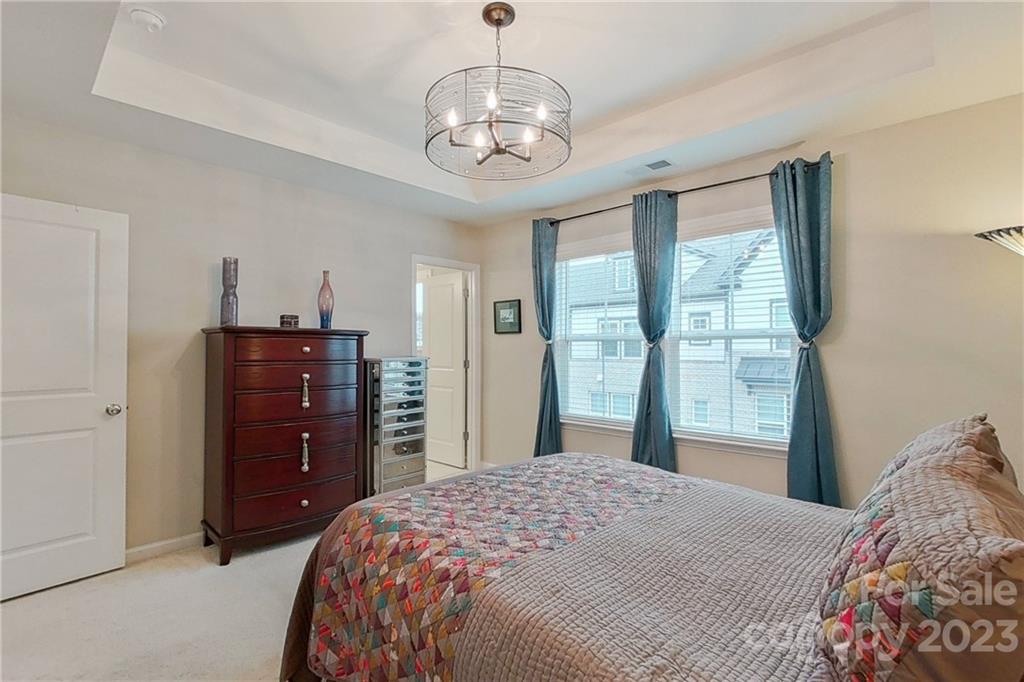 511 Upper Stone Circle Charlotte, NC 28211 - Photo 20 of 32 a bedroom with a bed and a chandelier