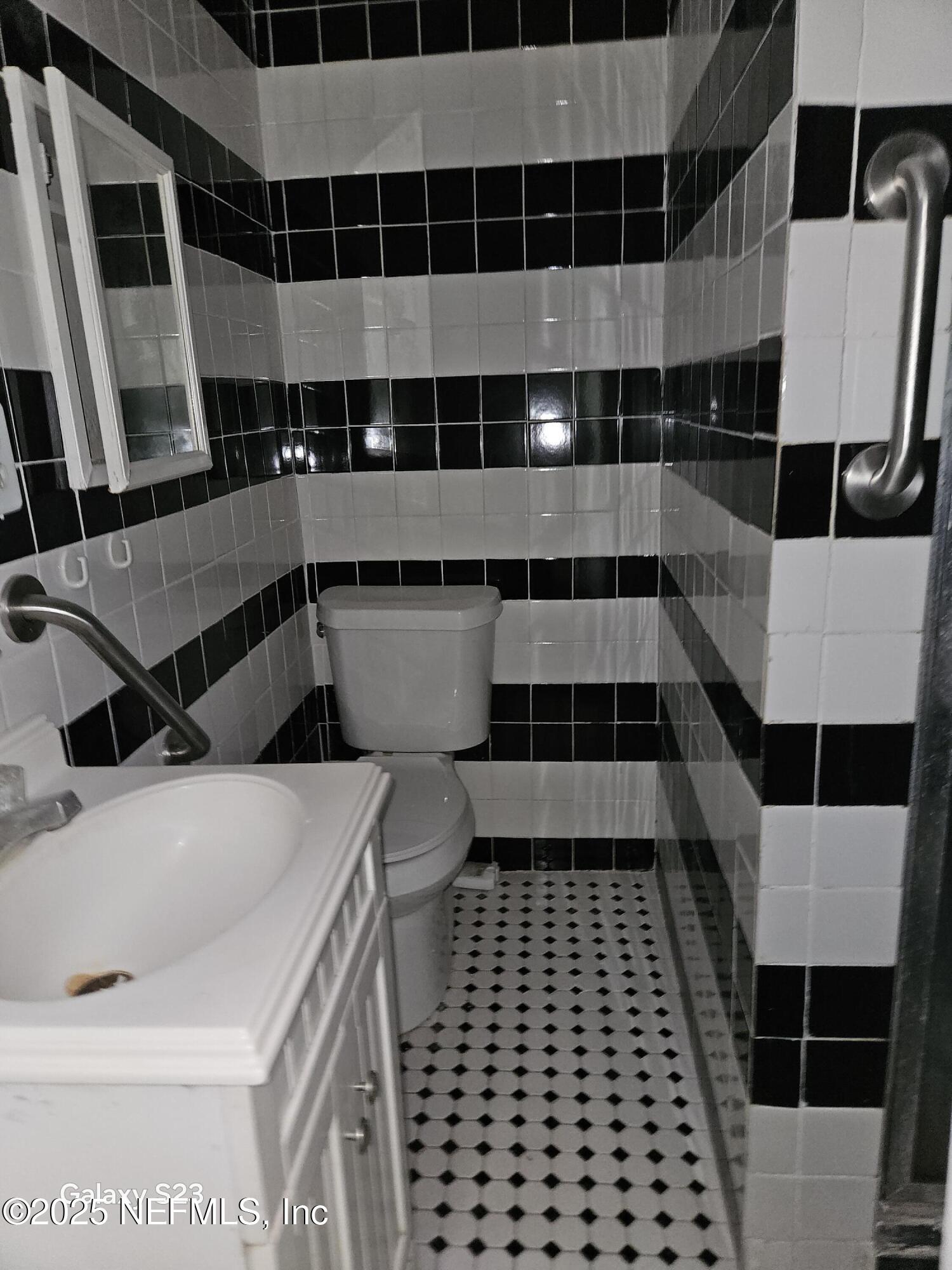 6526 Ribault Road Jacksonville, FL 32209 - Photo 6 of 13 a bathroom with a black white checkered floor and a sink