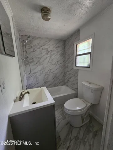 a bathroom with a sink a toilet and bathtub