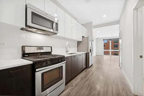 a kitchen with stainless steel appliances a stove microwave and sink