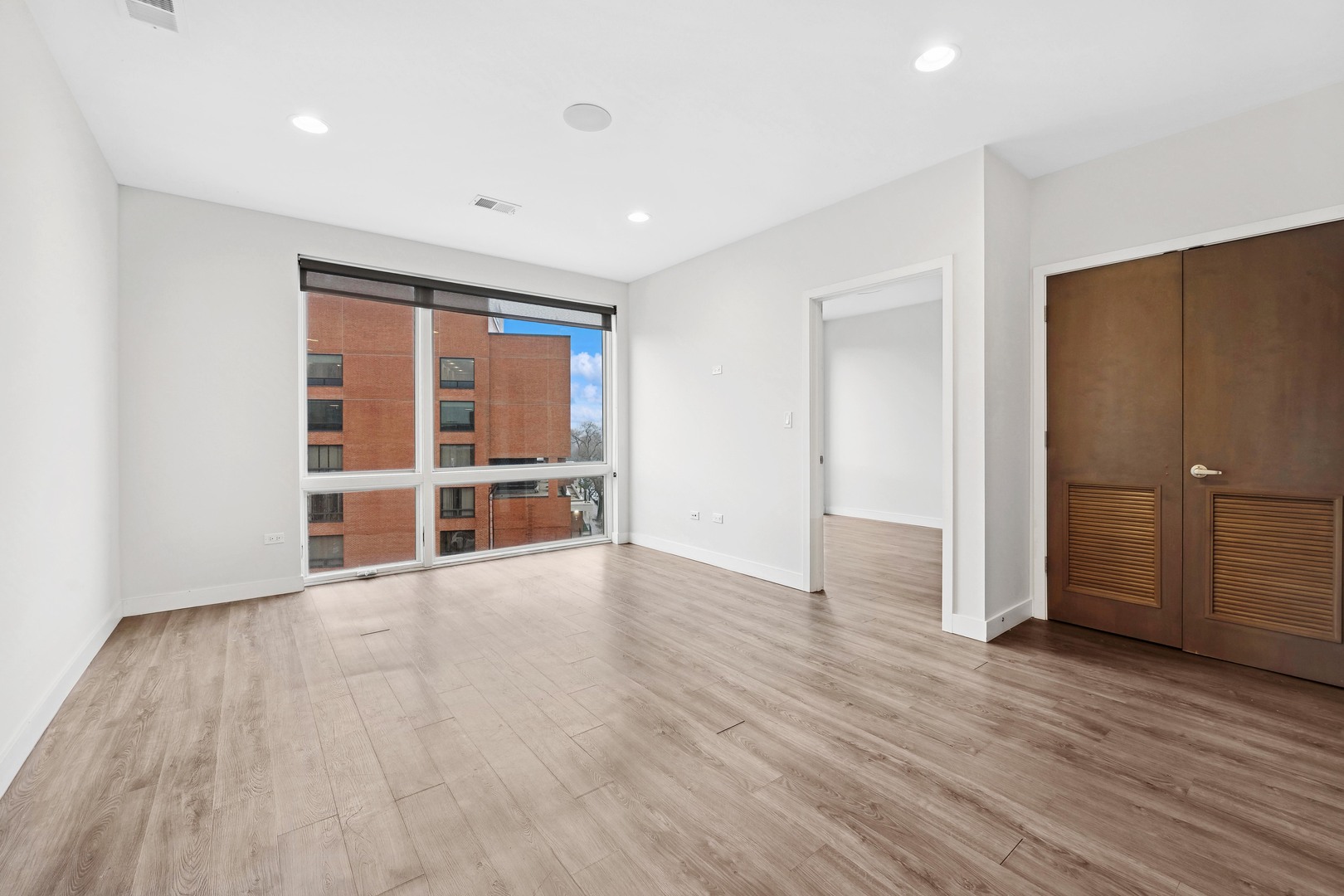 4027 North Broadway, Unit 501 Chicago, IL 60613 - Photo 3 of 14 a view of empty room with wooden floor and windows