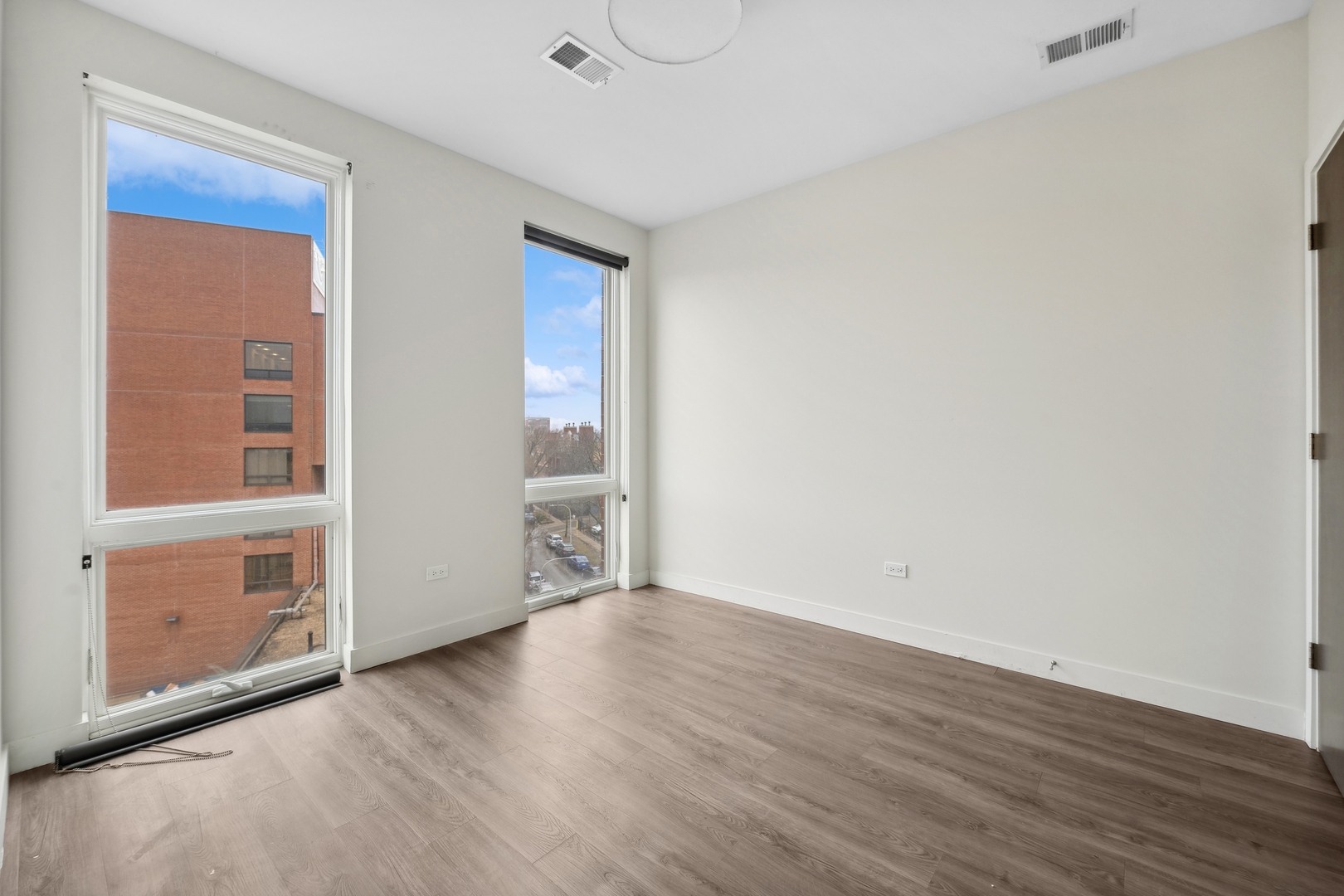 4027 North Broadway, Unit 501 Chicago, IL 60613 - Photo 5 of 14 an empty room with wooden floor and windows