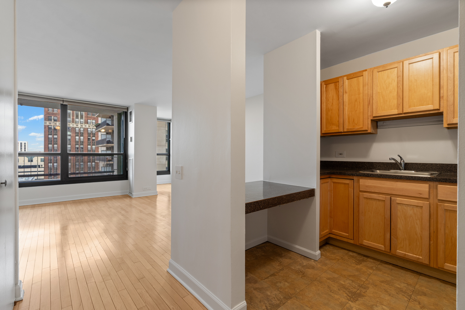1030 North State Street, Unit 5M Chicago, IL 60610 - Photo 5 of 14 a kitchen with stainless steel appliances granite countertop a stove a sink and a refrigerator with wooden floors