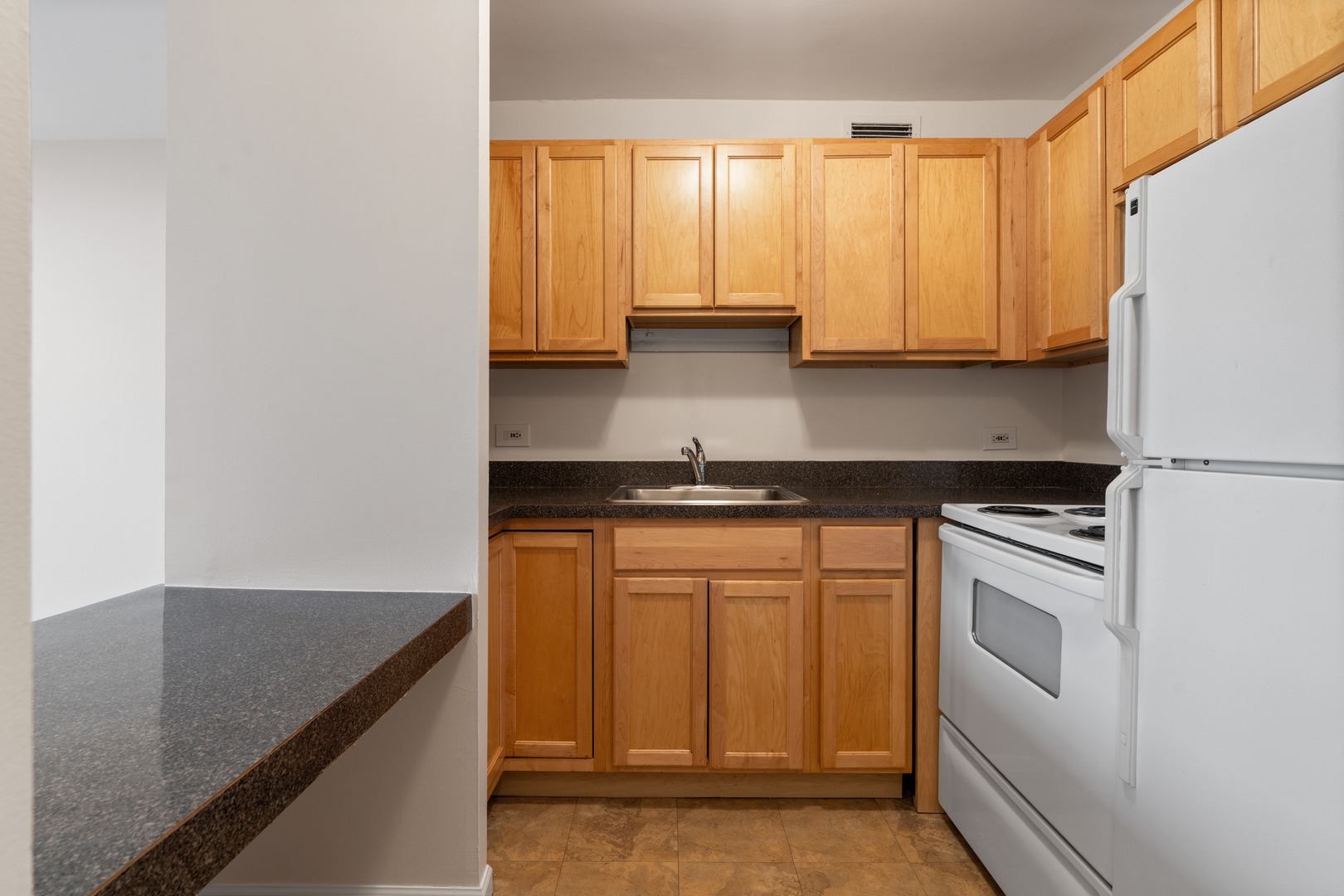 1030 North State Street, Unit 5M Chicago, IL 60610 - Photo 6 of 14 a kitchen with stainless steel appliances granite countertop a sink a stove and white cabinets
