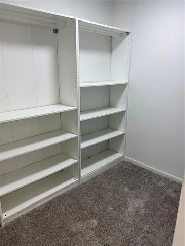 a view of walk in closet with empty racks