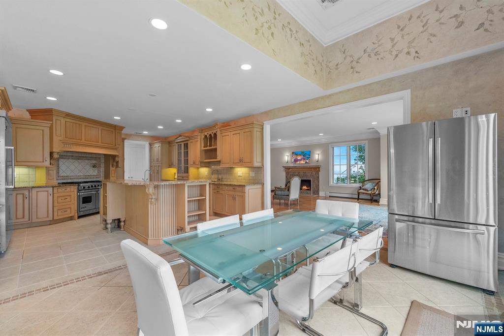 1 Euclid Road Fort Lee, NJ 07024 - Photo 15 of 50 a kitchen with stainless steel appliances kitchen island granite countertop a refrigerator a stove a sink a dining table and chairs with wooden floor