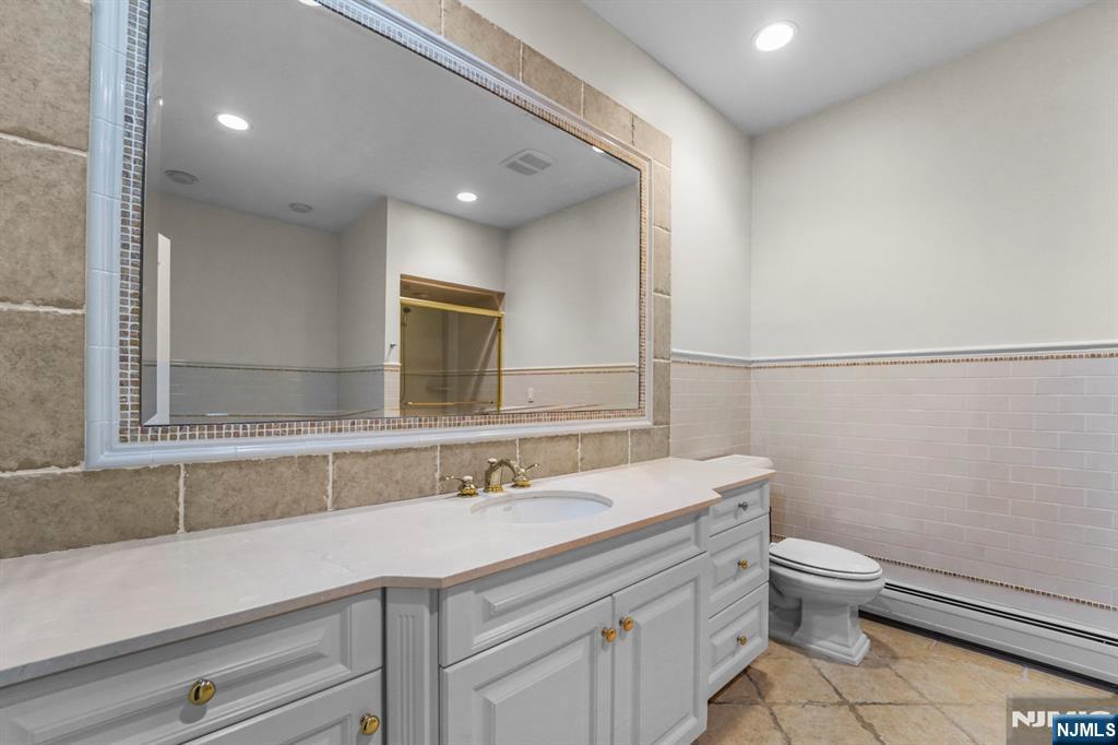 1 Euclid Road Fort Lee, NJ 07024 - Photo 30 of 50 a bathroom with a sink a toilet a mirror and shower