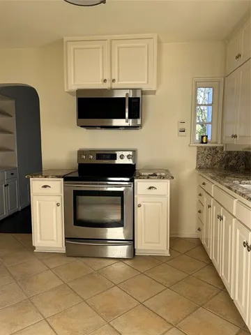 a kitchen with stainless steel appliances a stove a microwave and a sink