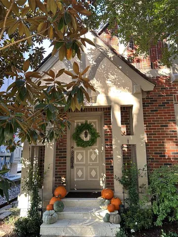 a front view of a house with large trees