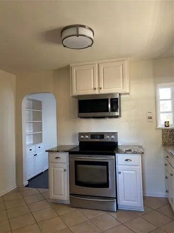 a kitchen with stainless steel appliances granite countertop a stove and a microwave