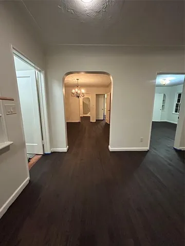 an empty room with wooden floor and mirror