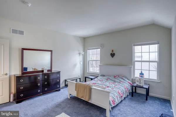 a bedroom with a bed a couch and dresser