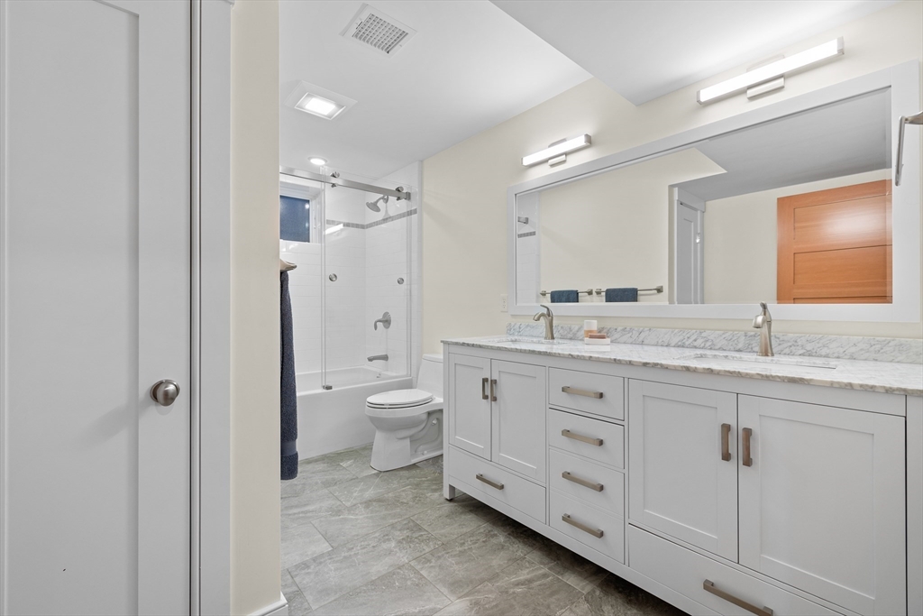 2 Village Street, Unit 2 Somerville, MA 02143 - Photo 13 of 18 a spacious bathroom with a granite countertop sink a mirror a toilet and a shower