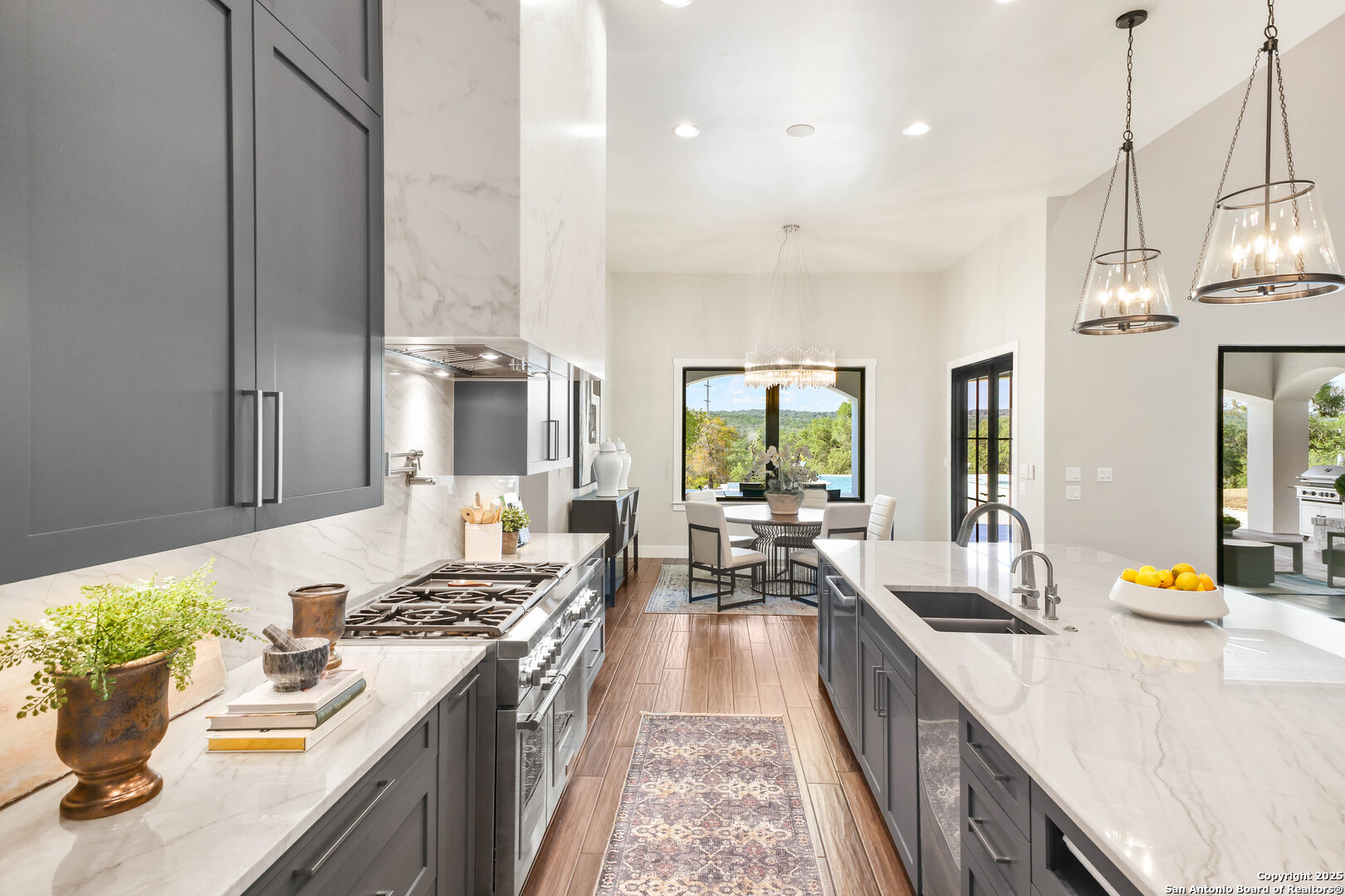 596 Ruger Road Fredericksburg, TX 78624 - Photo 18 of 63 a open kitchen with stainless steel appliances granite countertop a lot of counter space and wooden floors