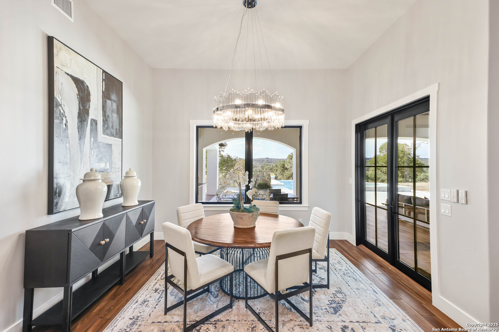 596 Ruger Road Fredericksburg, TX 78624 - Photo 19 of 63 a dining room with furniture a chandelier and wooden floor