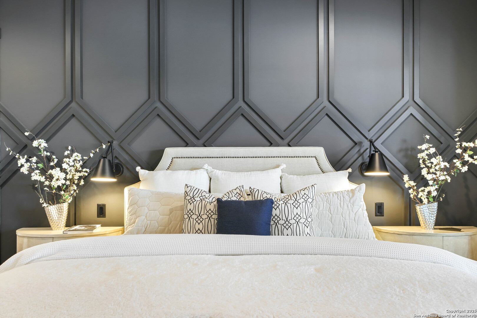 596 Ruger Road Fredericksburg, TX 78624 - Photo 23 of 63 a bedroom with a large bed and a chandelier