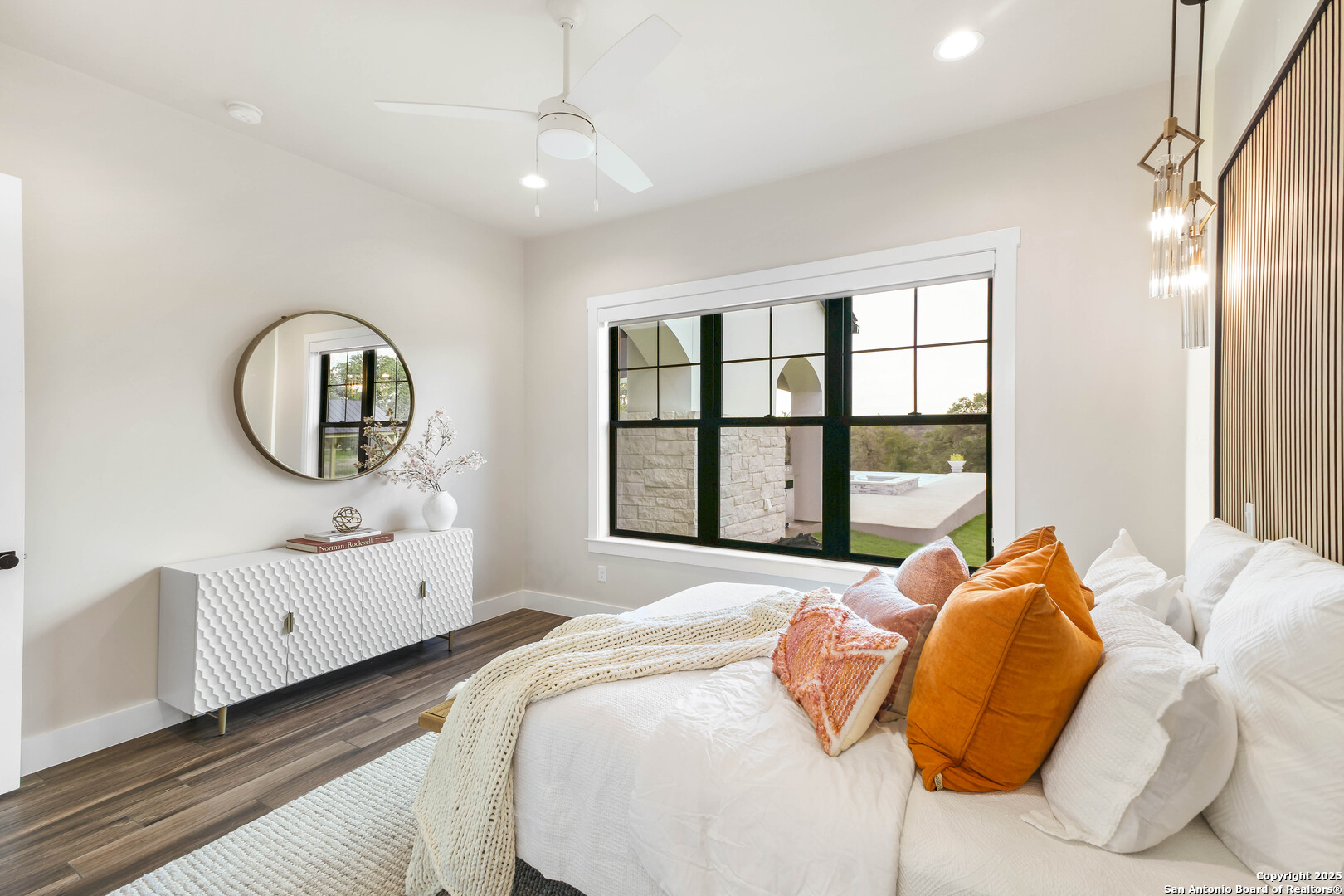 596 Ruger Road Fredericksburg, TX 78624 - Photo 29 of 63 a bedroom with a bed mirror on dresser and a large window