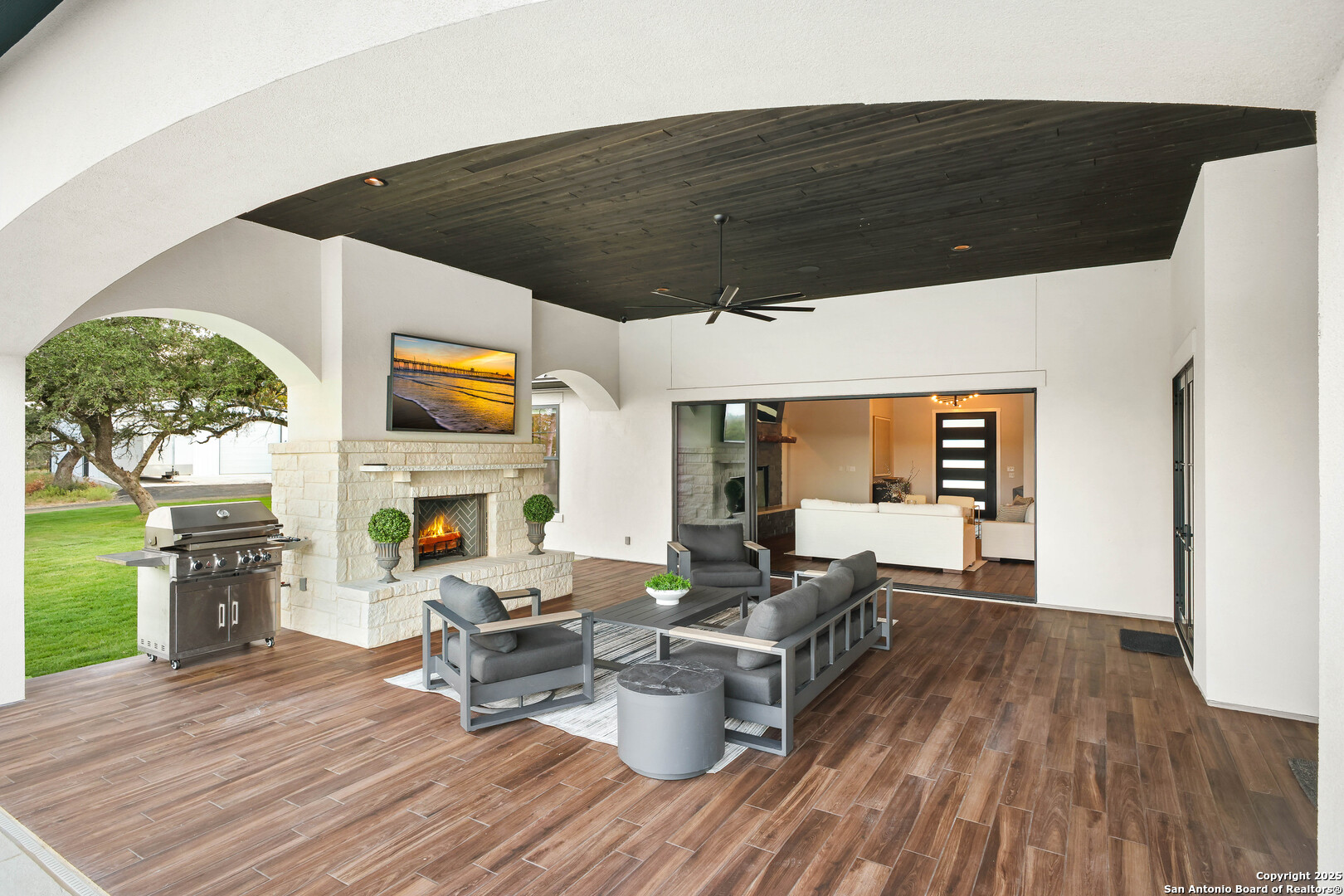 596 Ruger Road Fredericksburg, TX 78624 - Photo 43 of 63 a living room with furniture a fireplace and a floor to ceiling window