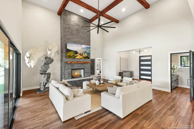 a living room with furniture a fireplace and a flat screen tv