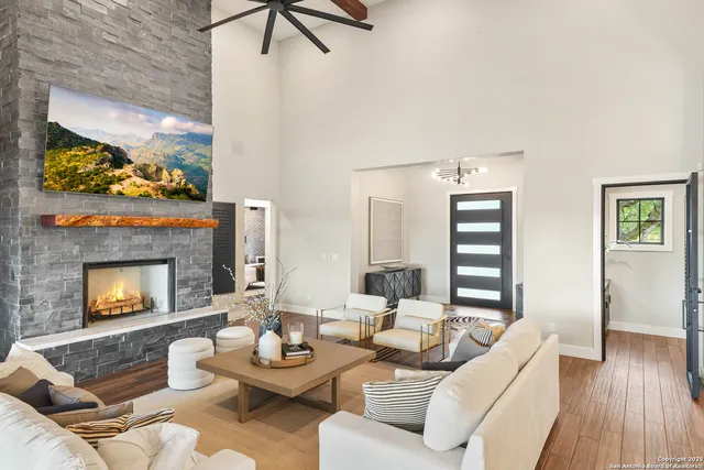 a living room with furniture a fireplace and a floor to ceiling window