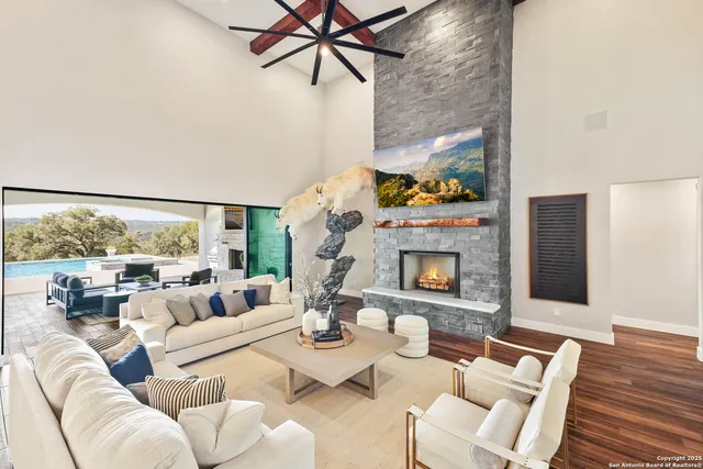 a living room with furniture kitchen view and a wooden floor