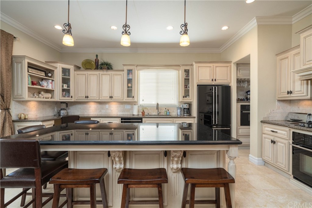 19032 Mono Drive Hesperia, CA 92345 - Photo 50 of 54 a kitchen with stainless steel appliances granite countertop a stove top oven a refrigerator a sink and chairs