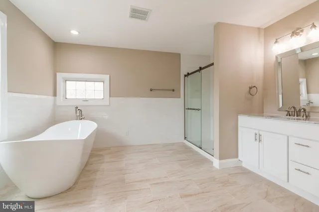 a spacious bathroom with a bathtub and a sink