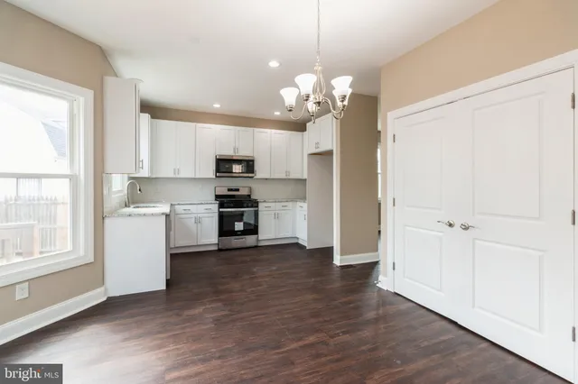 a view of a kitchen with a sink a refrigerator and window