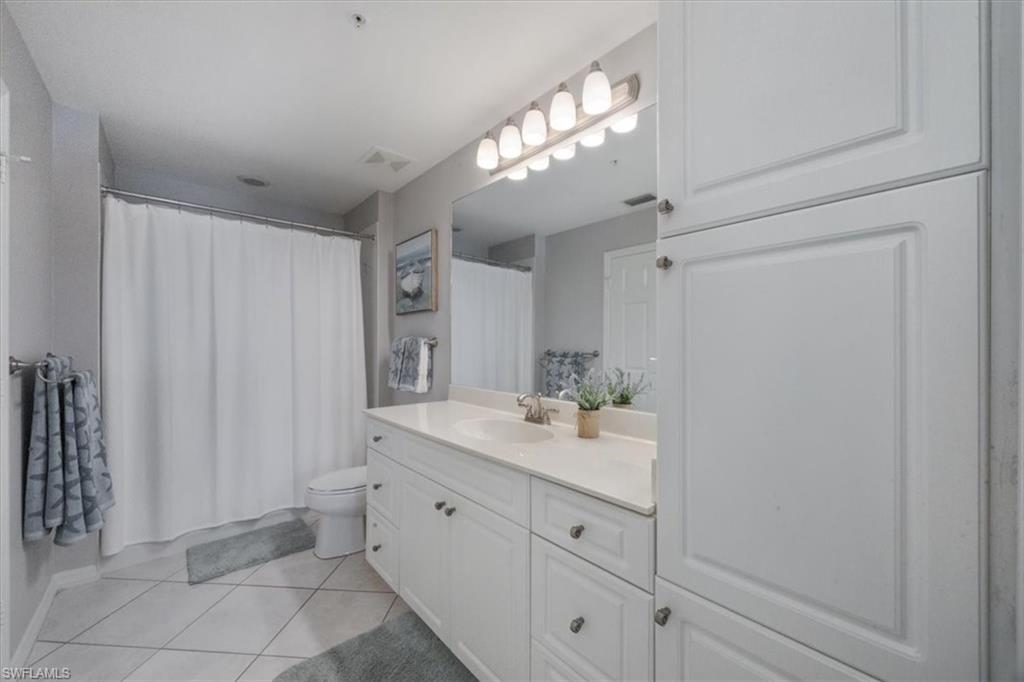 410 Bayfront Place, Unit 2403 Naples, FL 34102 - Photo 11 of 20 a spacious bathroom with a granite countertop sink a mirror and a shower