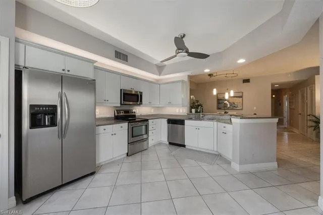 a large kitchen with a large counter top stainless steel appliances and cabinets