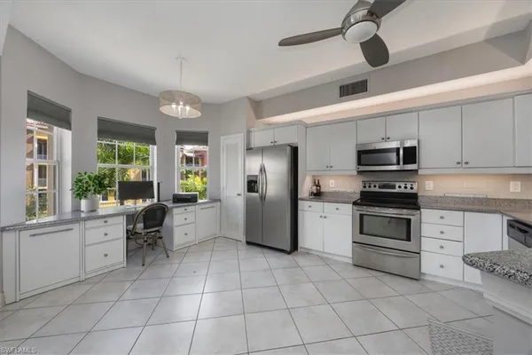 a kitchen with a stove a microwave and white cabinets