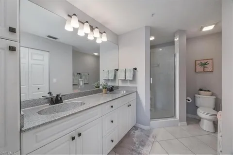 a spacious bathroom with a granite countertop sink a toilet and a mirror