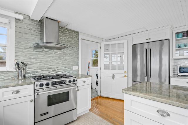 a kitchen with stainless steel appliances granite countertop a stove a sink and a refrigerator