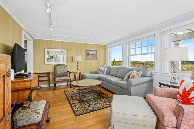 a living room with furniture a flat screen tv and a table
