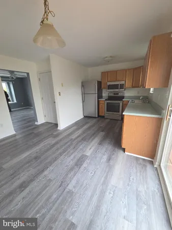 a view of a kitchen with wooden floor and electronic appliances