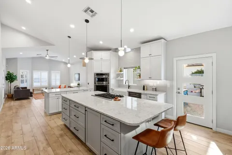 a living room with stainless steel appliances granite countertop furniture and a fireplace
