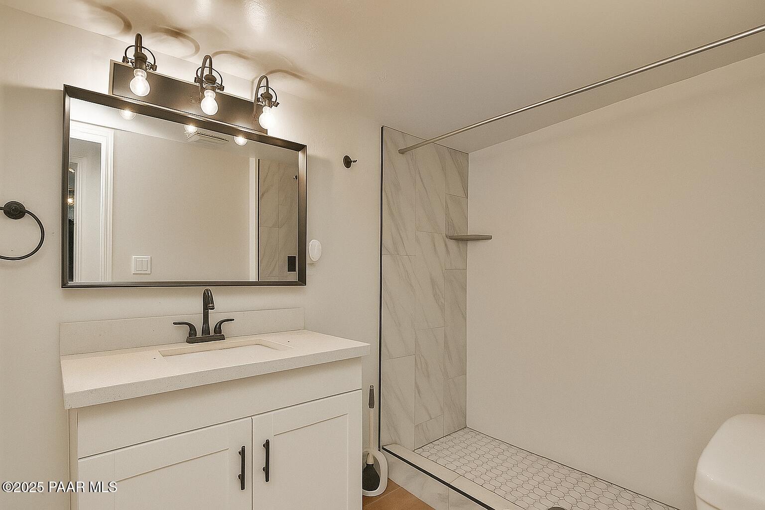 415 Comfort Avenue Prescott, AZ 86301 - Photo 2 of 10 a bathroom with a sink a toilet a mirror and shower