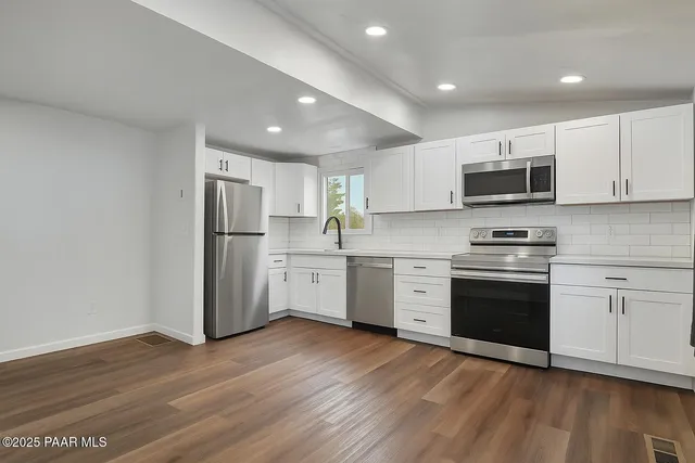 a kitchen with stainless steel appliances a stove a sink and a microwave