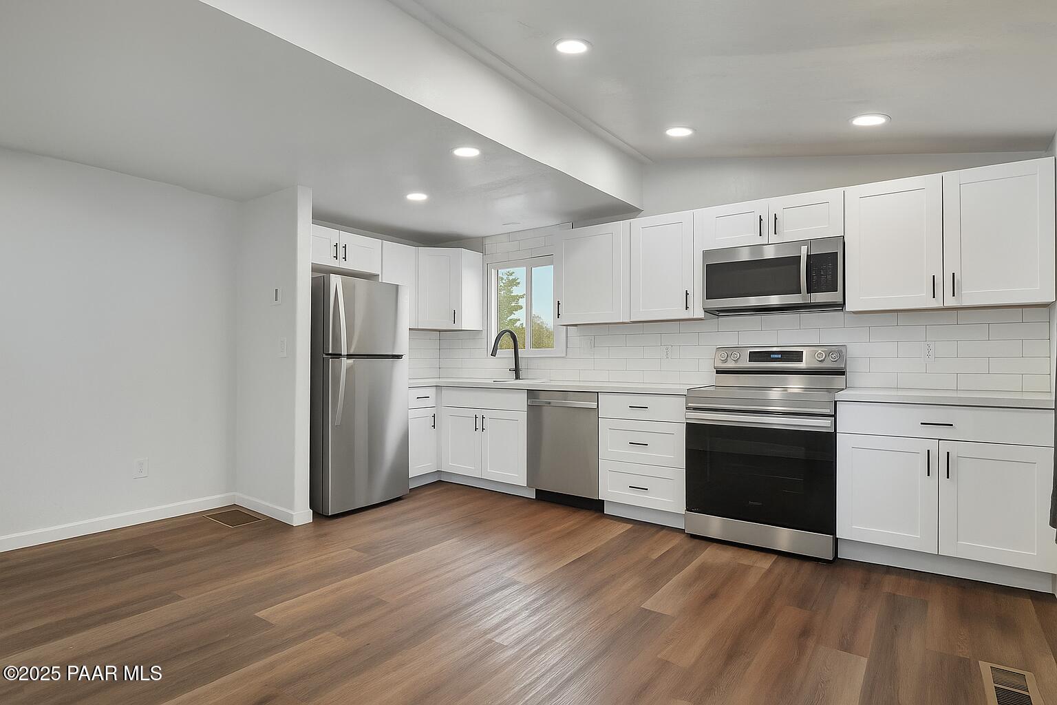 415 Comfort Avenue Prescott, AZ 86301 - Photo 6 of 10 a kitchen with stainless steel appliances a stove a sink and a microwave