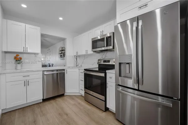 a kitchen with stainless steel appliances a refrigerator sink and microwave