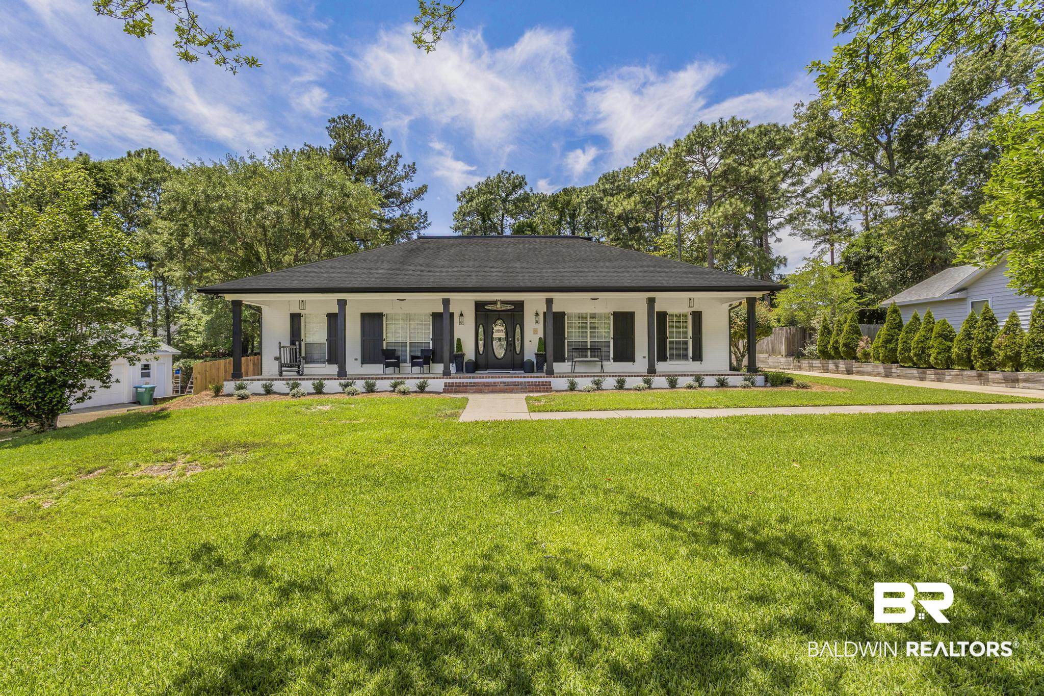 83 Caisson Trace Daphne, AL 36527 - Photo 2 of 63 Single-story residence featuring a white facade, dark shutters, and a covered front porch with dark columns