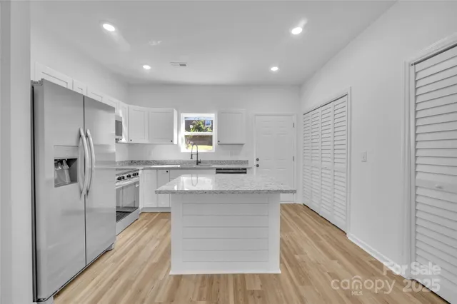 a kitchen with stainless steel appliances granite countertop a refrigerator and a sink