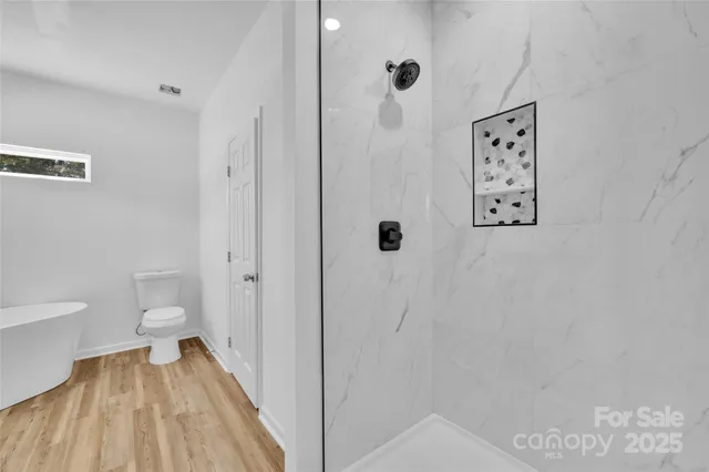 a bathroom with a toilet and a shower