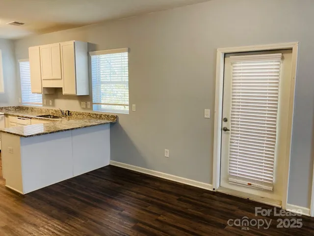 a kitchen with a wooden floor and a window