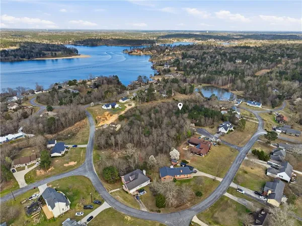 an aerial view of ocean and residential houses with outdoor space