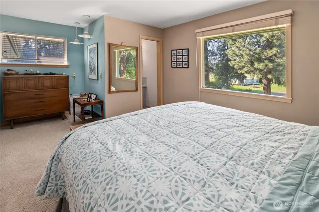 a bedroom with a bed a dresser and a window