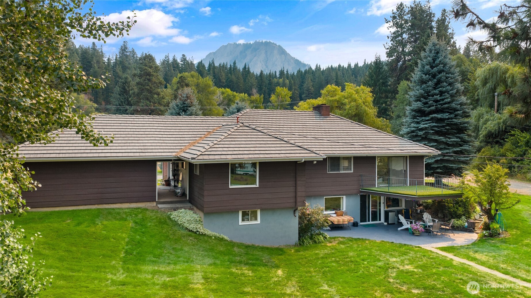 911 Westside Road Cle Elum, WA 98922 - Photo 2 of 40 a front view of a house with garden and chairs